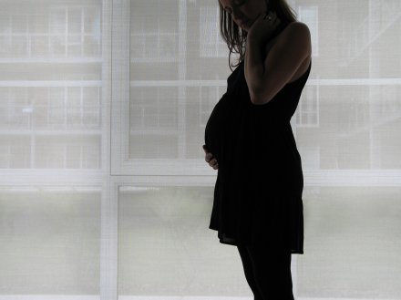 Pregnant woman standing at window